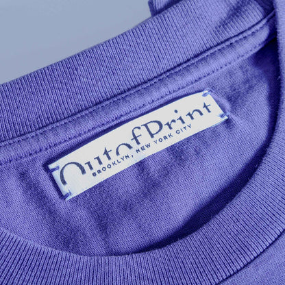 Close-up of a purple garment with 'MutaPrint' label on a light blue background