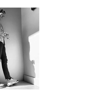 Person standing next to a white cabinet with a mirror on a white background